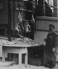 Photograph showing detail of butchers' working bench and hooks for meat